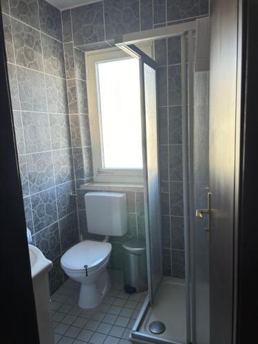 a bathroom with a toilet and a window at Hotel Berg in Seekirchen am Wallersee
