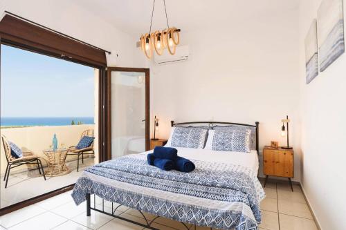 a bedroom with a bed with a view of the ocean at Villa Petalouda by Villa Plus in Kalathos