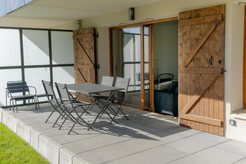 un patio avec une table et des chaises et une porte coulissante dans l'établissement Appartement Gentiane, à Les Déserts