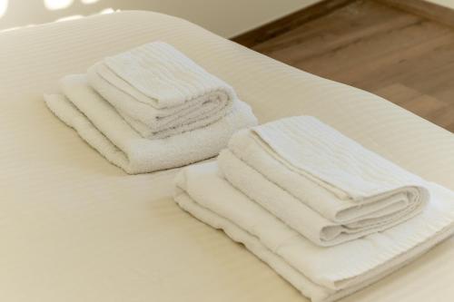 two stacks of white towels sitting on a table at Appartement Gentiane in Les Déserts