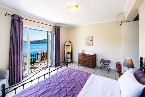 a bedroom with a bed and a view of the ocean at Villa Votsalo Desimi by Villa Plus in Katokhórion