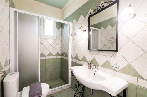 a bathroom with a sink and a shower and a toilet at Villa Votsalo Desimi by Villa Plus in Katokhórion