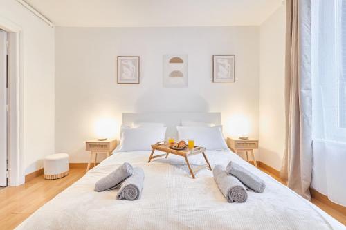 - une chambre blanche avec un lit et une table dans l'établissement Le Cocon, Centre-ville, Calme, 4 personnes, Proche commerces, à Reims