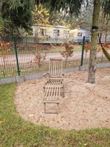 a wooden bench sitting next to a tree at Chata Braci Warchały in Warchały