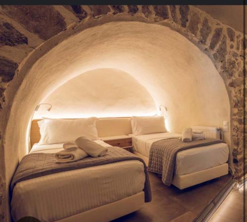 two beds in a room with an archway at Holidays in Chania Hotel in Chania