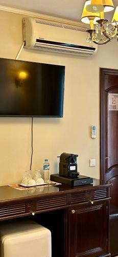 a hotel room with a large flat screen tv on the wall at Pensiunea Aristocrat in Iaşi