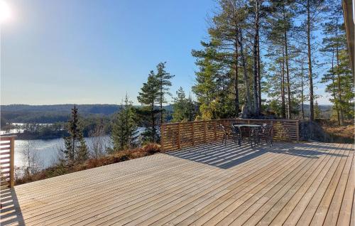 a wooden deck with a table and chairs on it at 3 Bedroom Lovely Home In Vatnestrøm in Birkeland