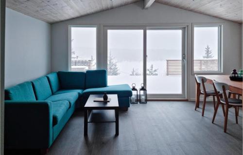 a living room with a blue couch and a table at 3 Bedroom Lovely Home In Vatnestrøm in Birkeland