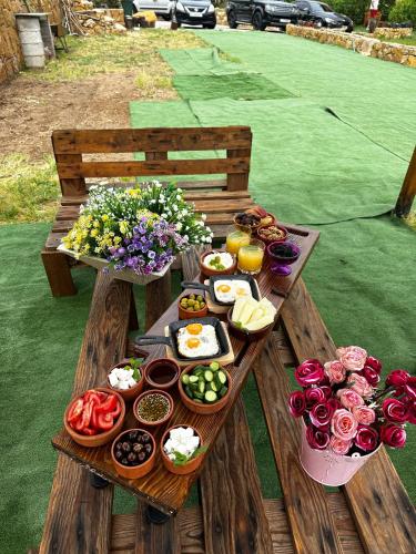 a picnic table with plates of food and flowers at Rokwood faraya in Ash Sha‘rah