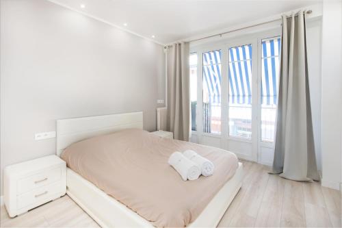 a white bedroom with two towels on a bed at Sublime 3P à la frontière de Monaco in Beausoleil