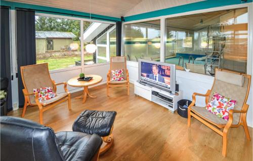 a living room with three chairs and a flat screen tv at Awesome Home In Løkken With Sauna in Lønstrup