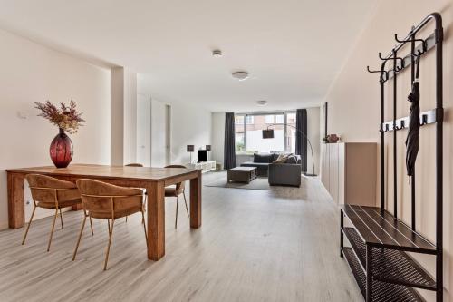 a living room with a wooden table and chairs at Eindhoven City Suites Hertogstraat G Modern 2P in Eindhoven