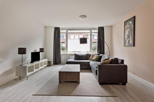 a living room with a couch and a table at Eindhoven City Suites Hertogstraat G Modern 2P in Eindhoven