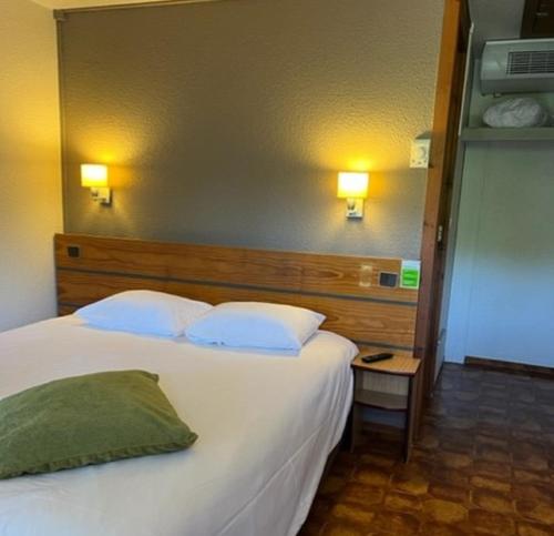 a bedroom with a large bed with two pillows at Campanile Dax - Saint-Paul-Les-Dax in Saint-Paul-lès-Dax
