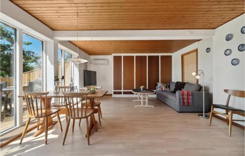 a living room with a couch and a table and chairs at Nice Apartment In Aakirkeby With Wifi in Åkirkeby