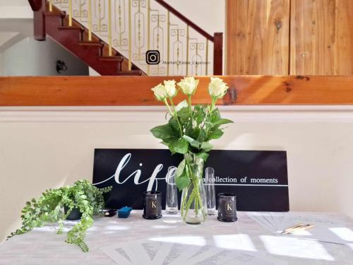 a table with a vase with flowers on it at Akamah Estate in Cape Town