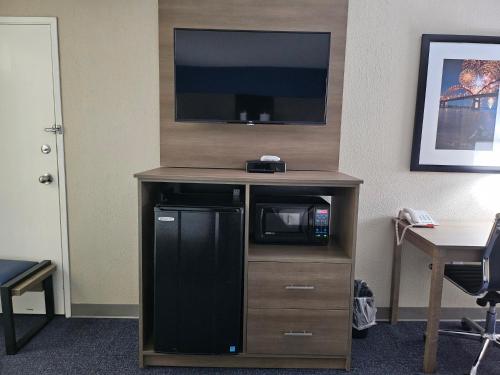 a tv on top of a wooden stand with a microwave at Baymont by Wyndham Davenport in Davenport