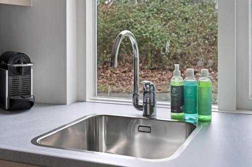a kitchen sink with two bottles of detergent next to a window at Jonkerstee 217 - Ouddorp - NOT FOR COMPANIES in Ouddorp