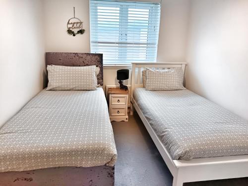 a bedroom with two beds and a window at 4 miles to Westhill by Lains Lettings in Aberdeen