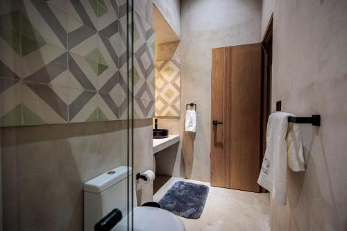 a bathroom with a toilet and a glass shower at Casa 1800 Oaxaca Boutique Hotel City Center based in Oaxaca City