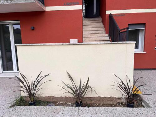 a building with stairs and two plants in front of it at Villa San Biagio Residence in Mason Vicentino