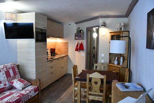Il comprend un petit salon avec une table et une cuisine. dans l'établissement Studio La Plagne Aime 2000 Paquebot Des Neiges Vue Pistes, à Aime La Plagne