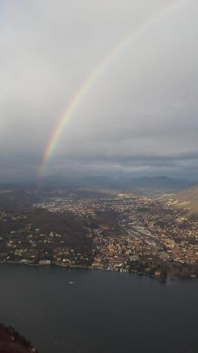 a rainbow in the sky over a city with a lake at B&B Il Balcone sul Lago in Brunate