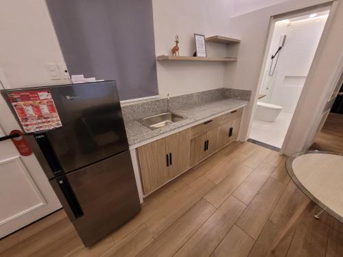 Una cocina con frigorífico de acero inoxidable y fregadero. en Ganada Presidential Suite room 가나다 스위트, en Ángeles