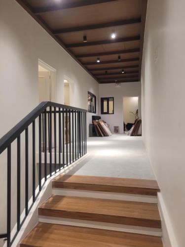 un pasillo con escaleras de madera y paredes blancas en Ganada Presidential Suite room 가나다 스위트, en Ángeles