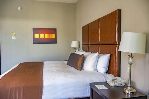 a hotel room with a bed and a telephone at Best Western PLUS Monterrey Airport in Monterrey
