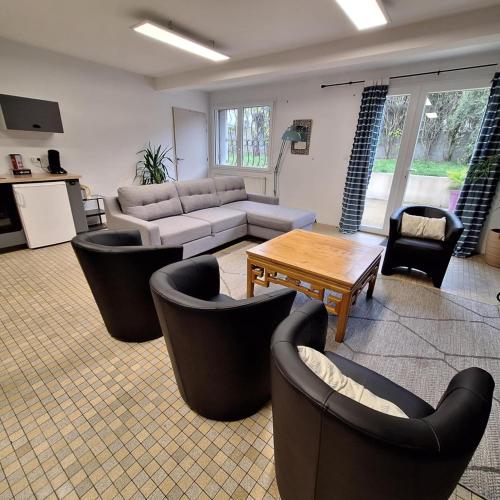 un salon avec des canapés, une table et des chaises dans l'établissement Appart jardin Kennedy, à Cholet