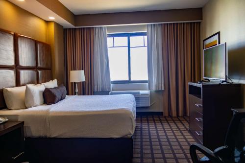 a hotel room with a bed and a television at Best Western PREMIER Monterrey Aeropuerto in Monterrey