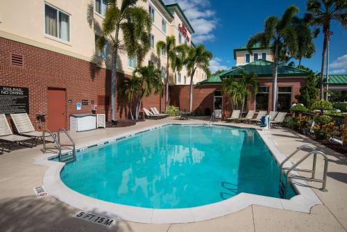 een zwembad voor een gebouw met palmbomen bij Hilton Garden Inn Tampa Ybor Historic District in Tampa