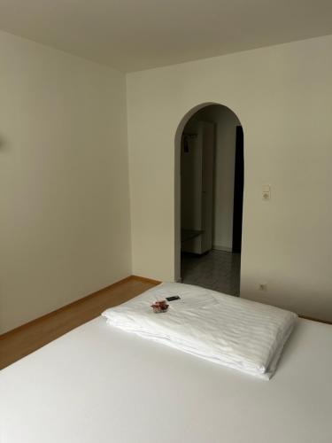 a bed in a white room with a white mattress at Hotel Berg in Seekirchen am Wallersee