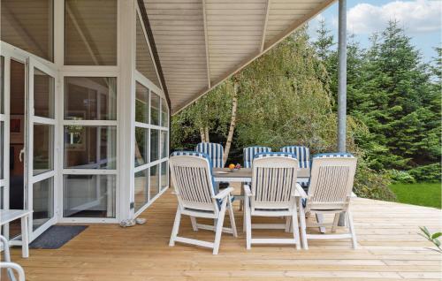 a porch with a table and chairs on it at Holiday Home Grusbakke Åsen in Vejby