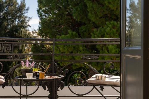 a table on a balcony with a view of trees at Panellinion Luxury Rooms in Kalamata