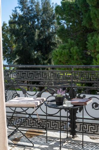 a patio with chairs and tables on a balcony at Panellinion Luxury Rooms in Kalamata