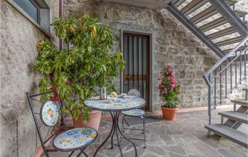 a table and chairs on a patio with plants at Awesome Home In Macchino With Kitchen in Marliana