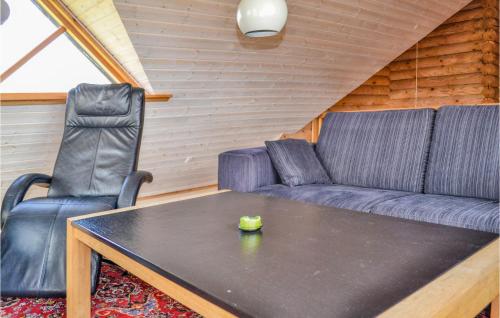 a living room with a couch and a table and two chairs at Holiday Home Brombærvej Xi in Lem