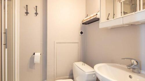 Un baño blanco con inodoro y lavabo. en Les Carlines N 412 - ST5, en Chamrousse