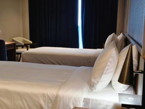 a hotel room with two beds with white pillows at Ocean View Hotel Kuwait in Kuwait