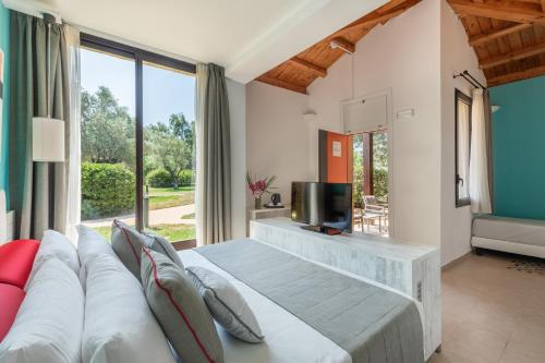 ein Schlafzimmer mit großem Bett und Fernseher in der Unterkunft VOI Floriana Resort in Simeri Mare