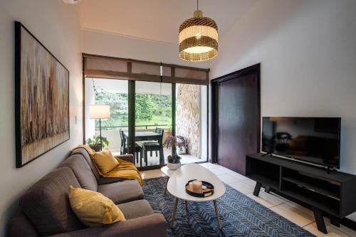 a living room with a couch and a flat screen tv at CR MARIPOSA RENTALS Mountain view near pool in Santa Ana
