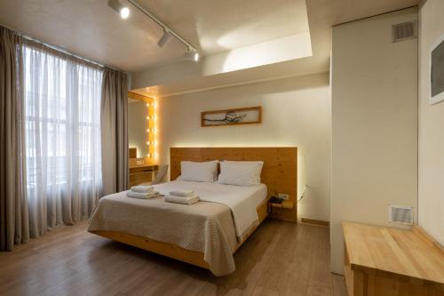 a bedroom with a bed and a large window at Panellinion Luxury Rooms in Kalamata
