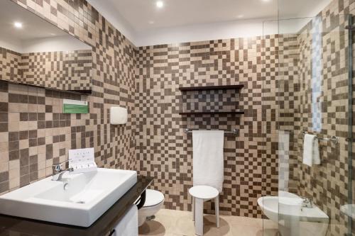 ein Badezimmer mit Waschbecken und Toilette in der Unterkunft VOI Floriana Resort in Simeri Mare