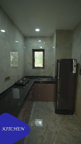 a kitchen with a black refrigerator and a window at Royal Retreat Lonavla - 7BHK Luxury Villa with Turf in Lonavala
