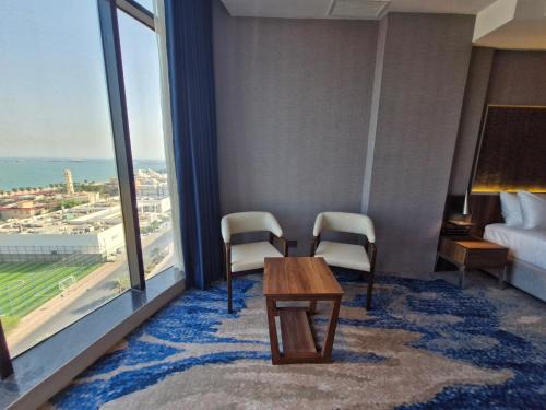 a room with a table and two chairs and a window at Ocean View Hotel Kuwait in Kuwait