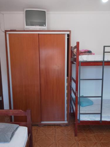 a room with a tv and a bunk bed at Hotel Pousada Liberdade in Pindamonhangaba