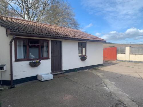 a small white house with a window and a door at The Old Stables in Barnsley