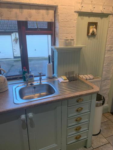 a kitchen counter with a sink and a window at The Old Stables in Barnsley